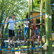 Kinder spielen auf einem Spielplatz mit vielen Hängebrücken und Klettermöglichkeiten