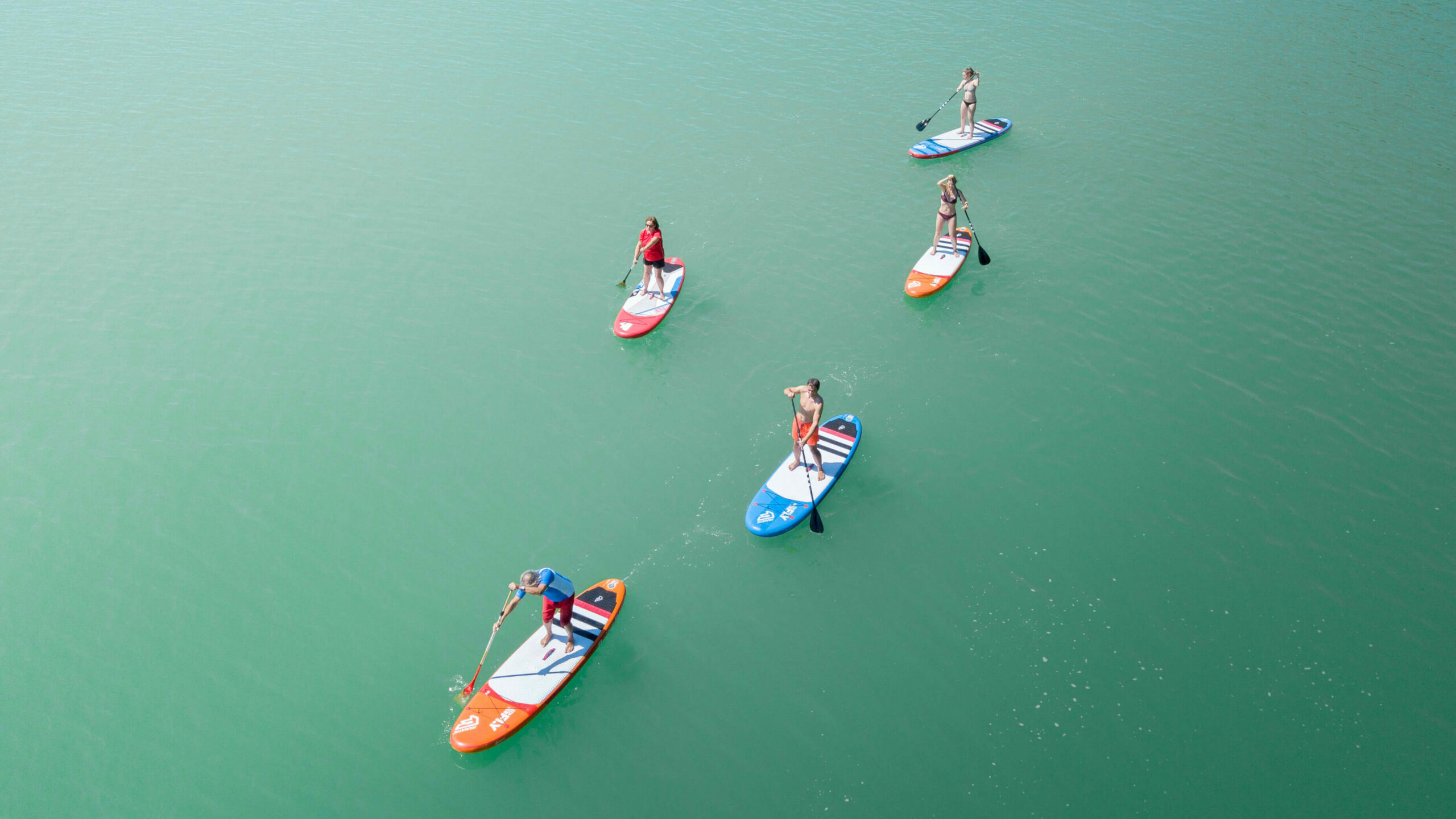 mehrere Stand-up-Paddler, die auf dem Waginger See fahren