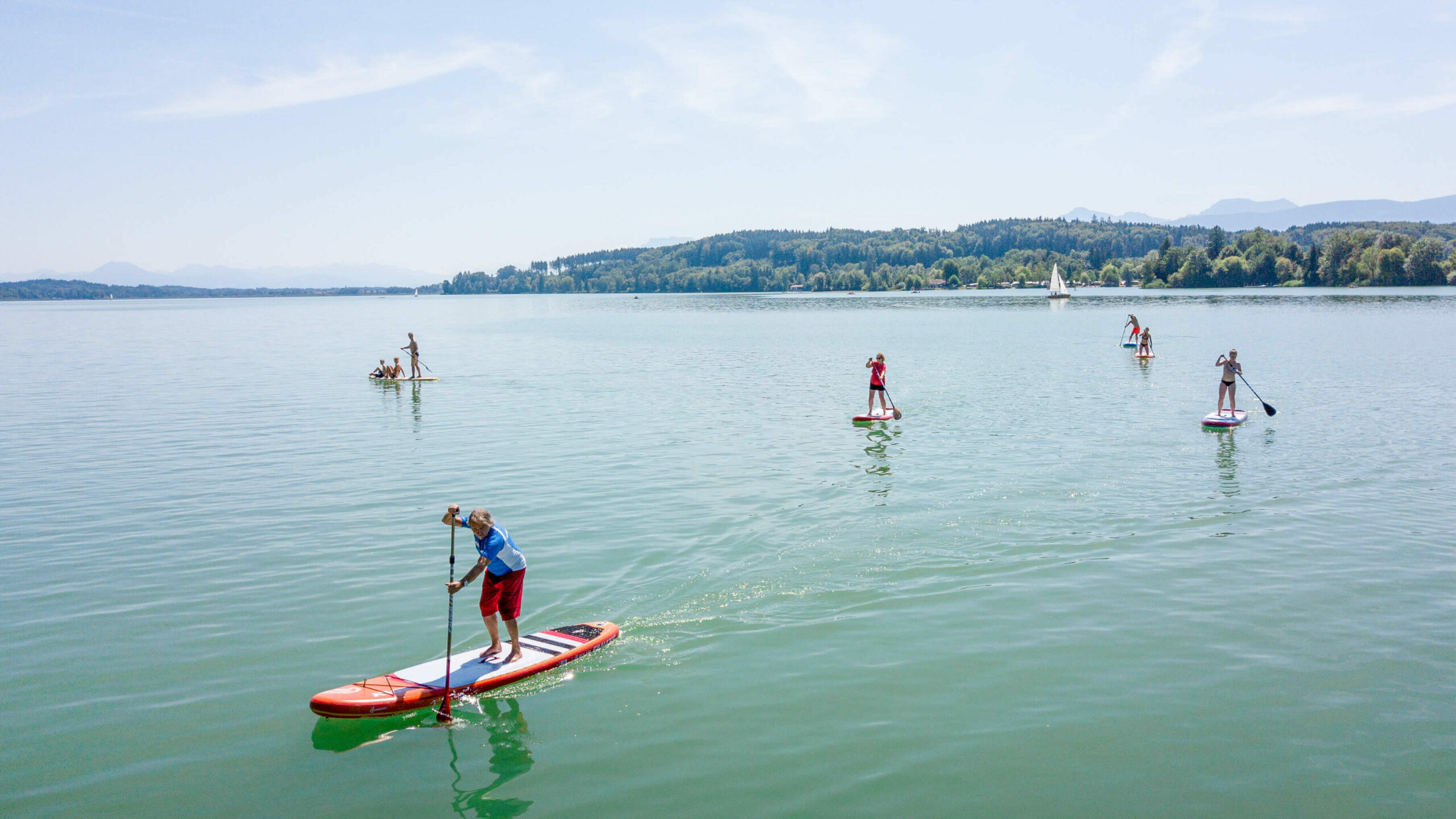 mehrere Stand-up-Paddler, die auf dem Waginger See fahren