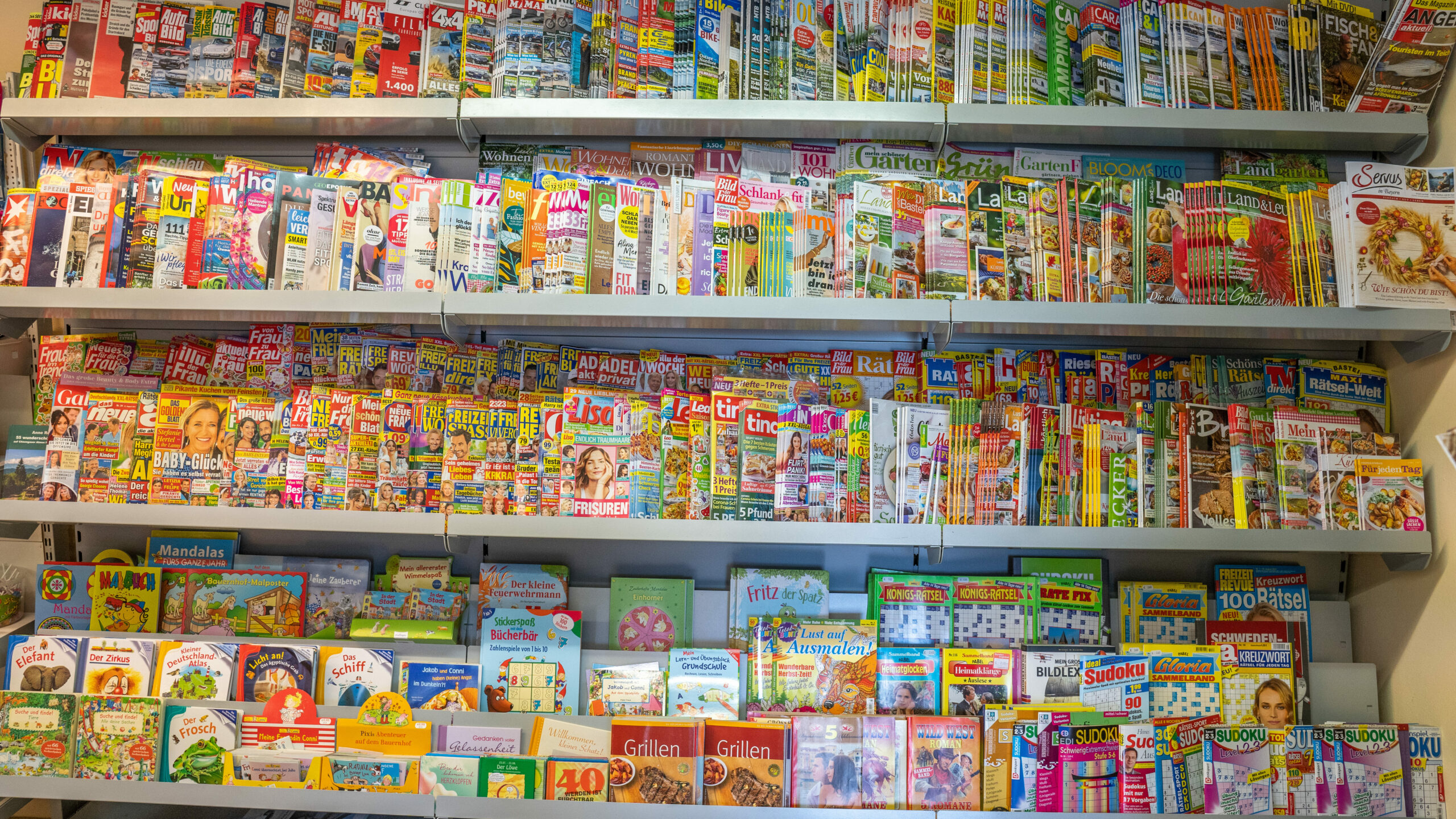 Viele bunte Zeitschriften in der Auslage eines Kiosk