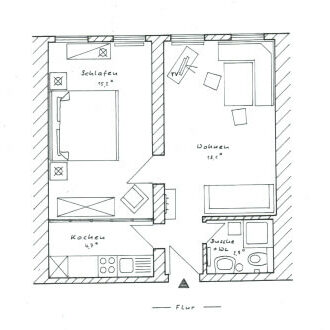 Grundrisszeichnung einer Ferienwohnung, bestehend aus einem Schlafzimmer mit Doppelbett, einem Wohnbereich mit Sofa und Esstisch, einer Küche und einem Bad mit Duche und WC