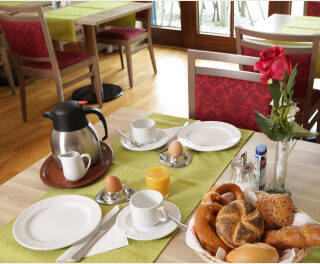 Ein übbig gedeckter Frühstückstisch mit Eiern, Brot und Kaffee