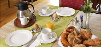 Ein übbig gedeckter Frühstückstisch mit Eiern, Brot und Kaffee